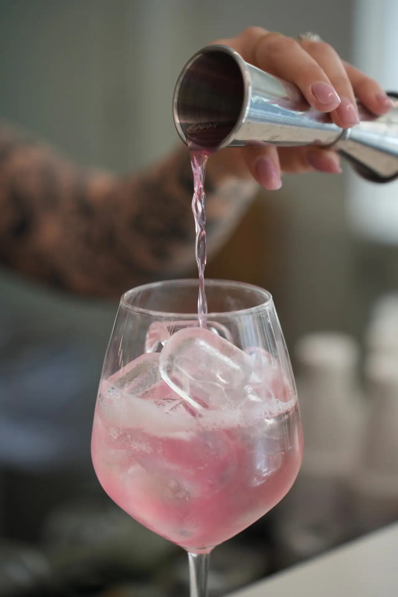 Il barman versa un gin tonic rosa