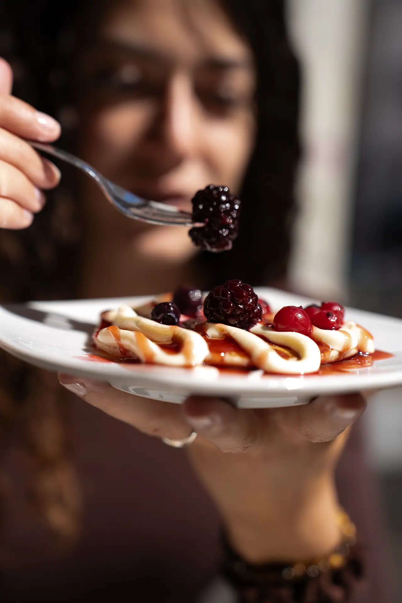 Una ragazza assaggia un dolce con frutti di bosco