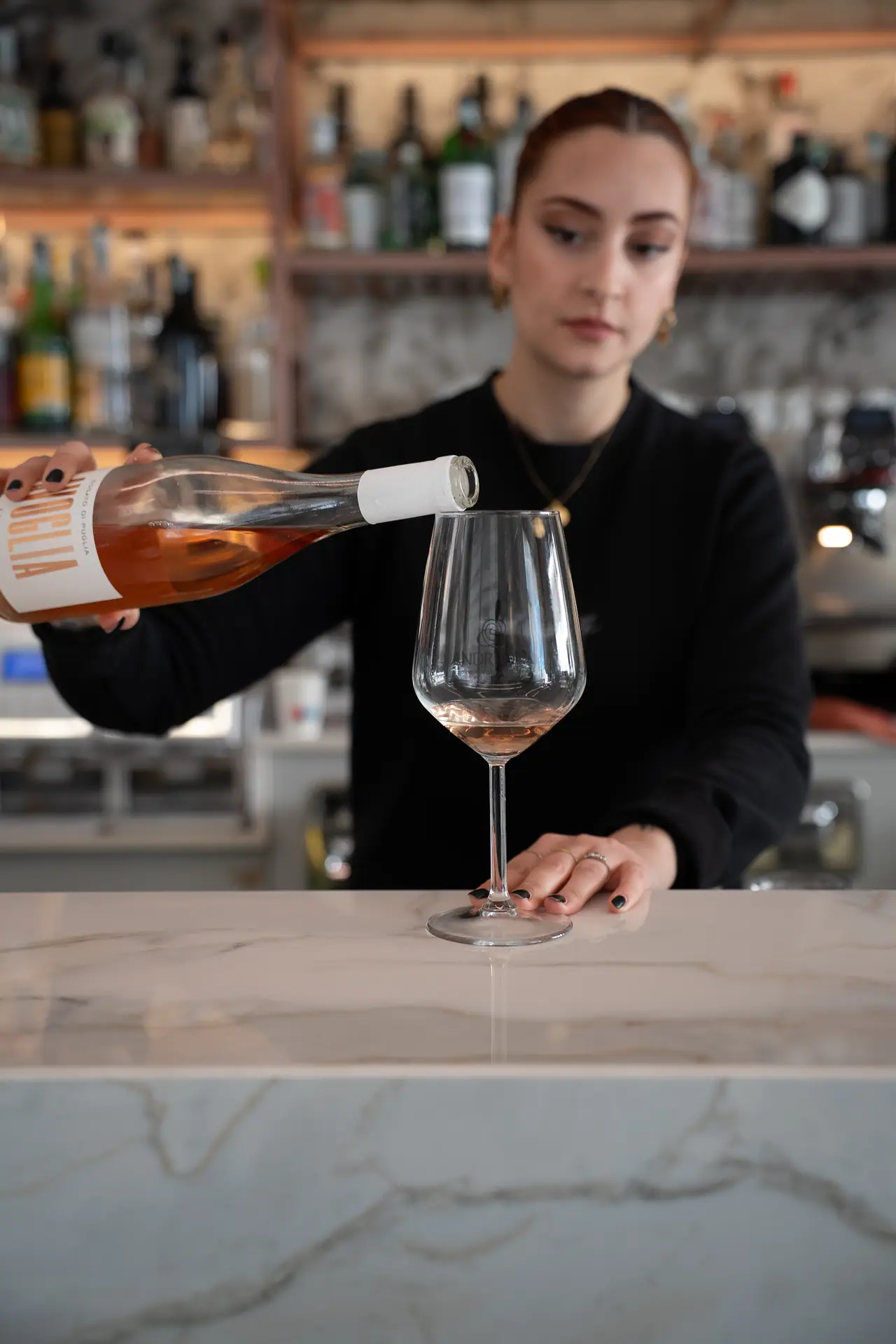 La barista versa un calice di vino