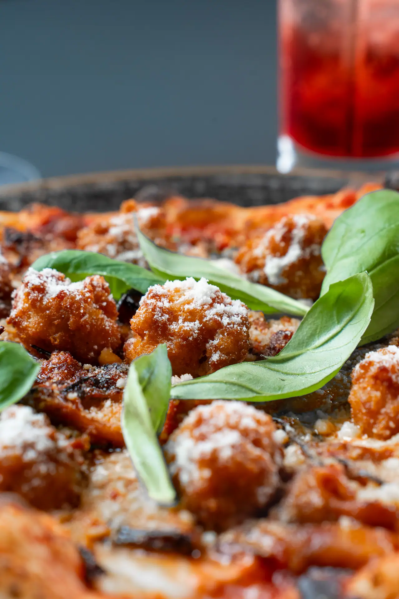 Pizza con polpette e basilico