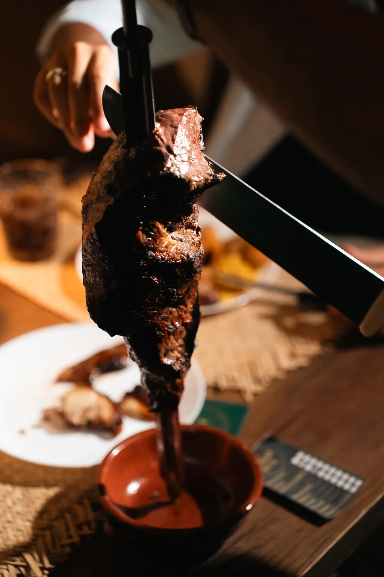 Il coltello del passador sulla carne allo spiedo