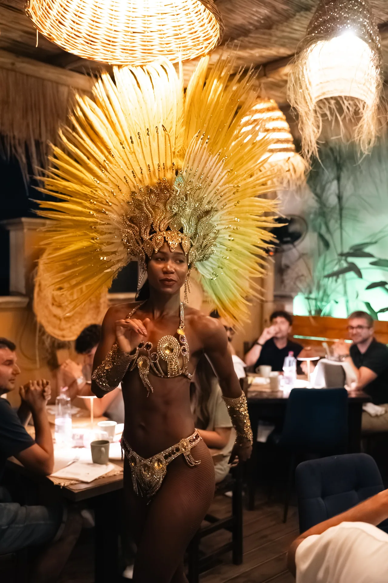 Ballerina di samba tra i tavoli sotto le lampade di rattan