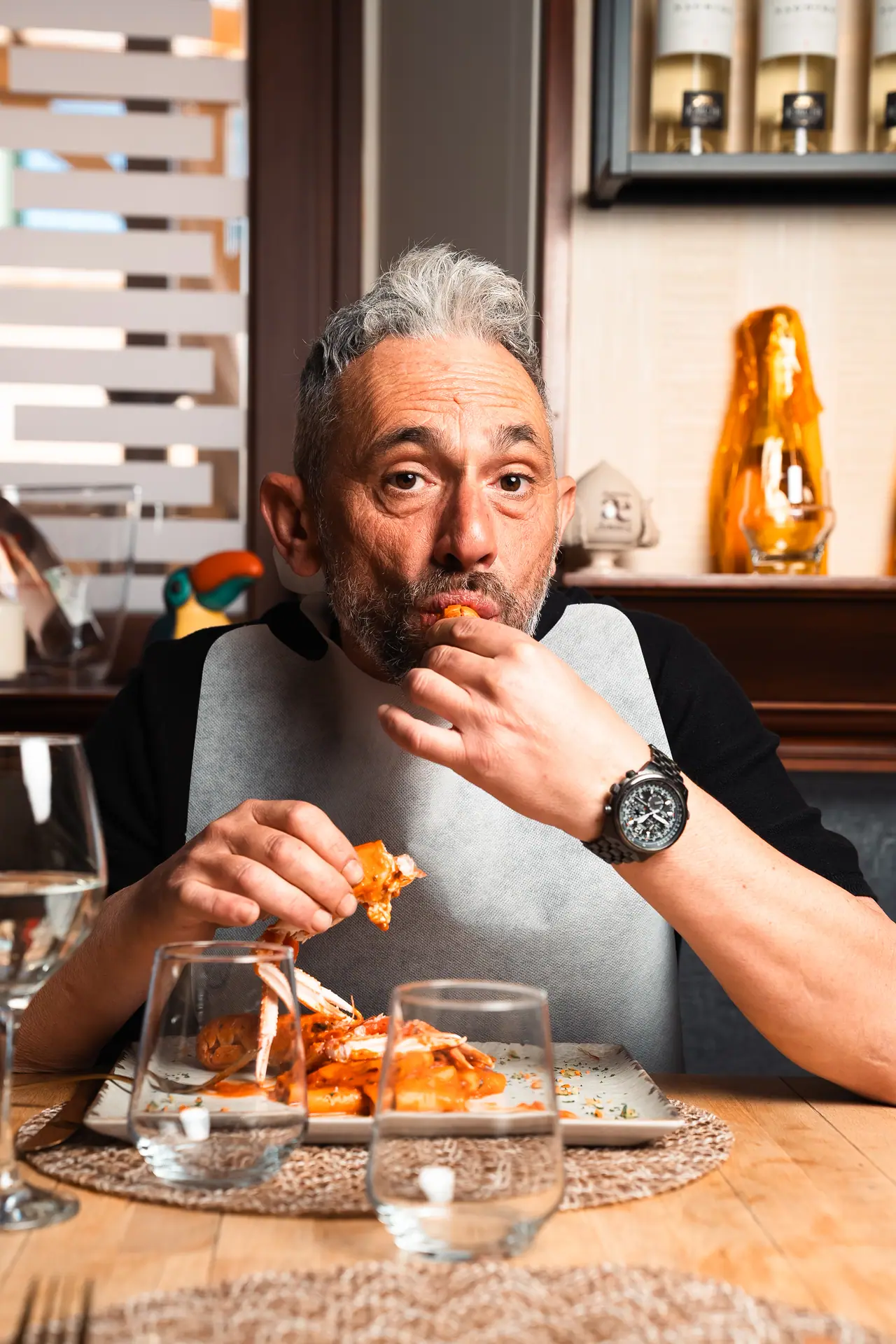 Un cliente con il bavaglio assaggia i crostacei