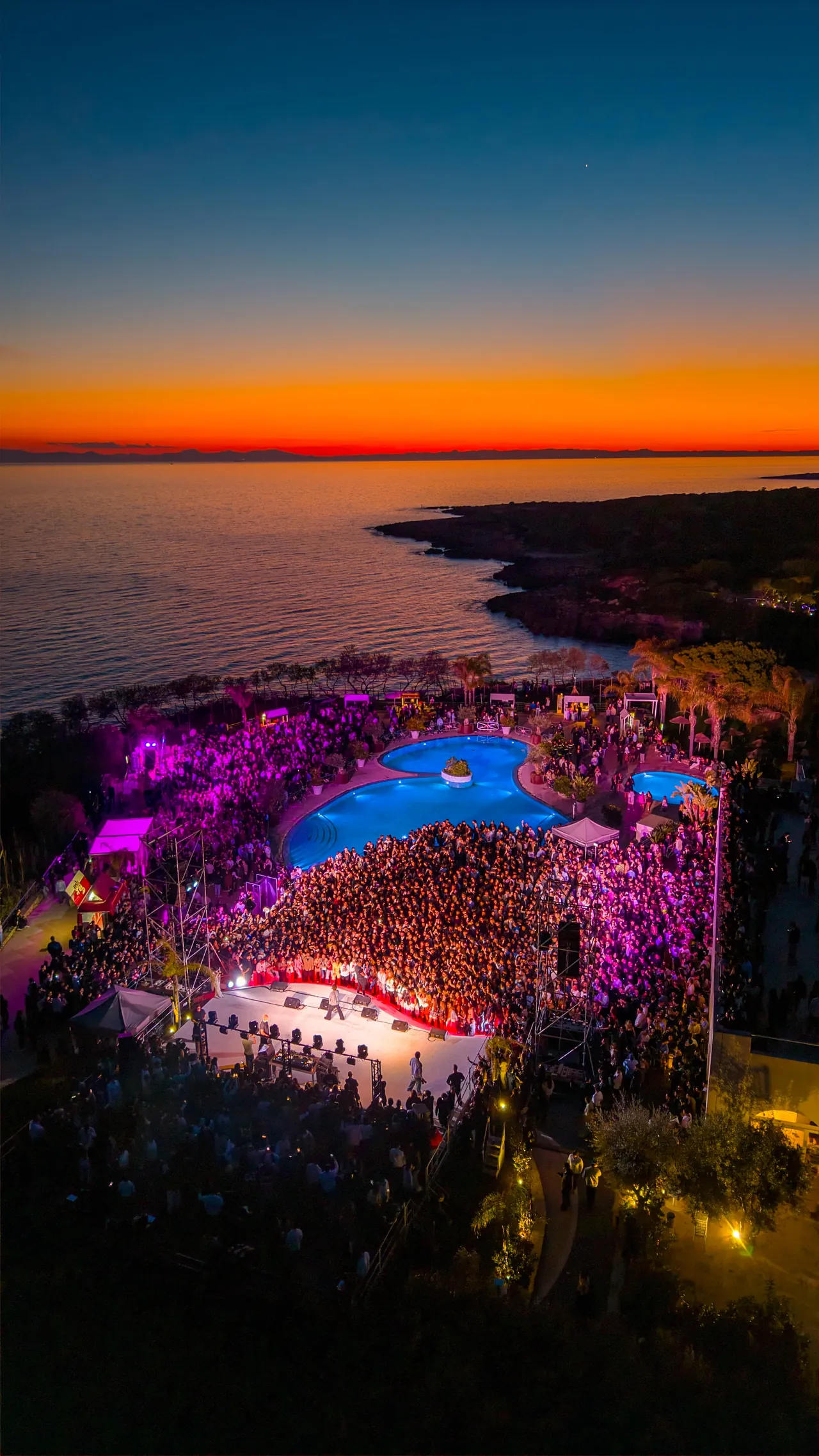 Il resort Mon Rêve dall’alto al tramonto, con il palco illuminato sul mare