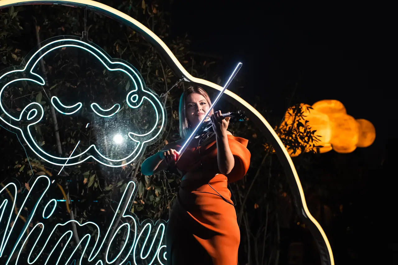 Violinista davanti all’insegna al neon Nimbus