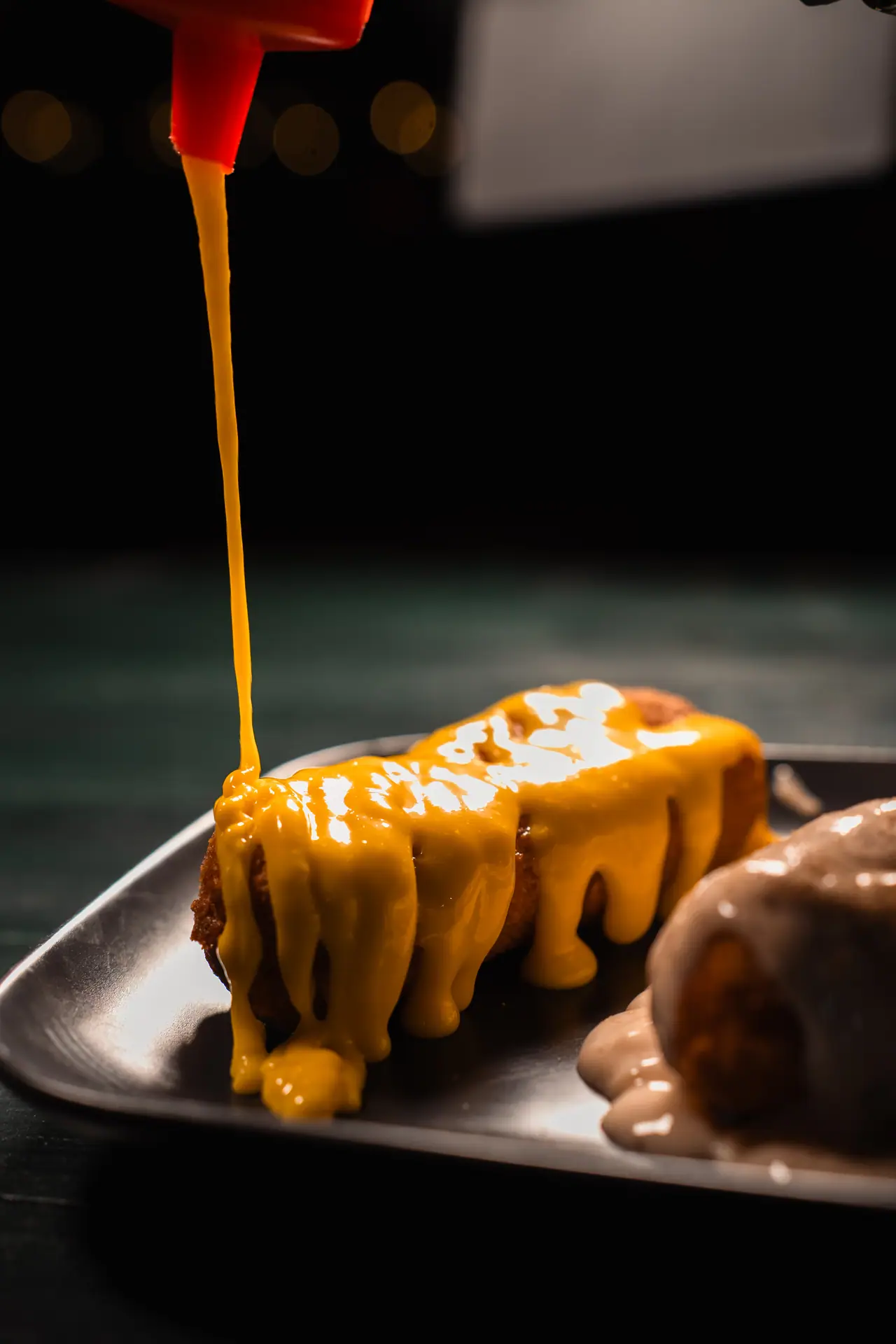 Salsa al formaggio versata su una frittura