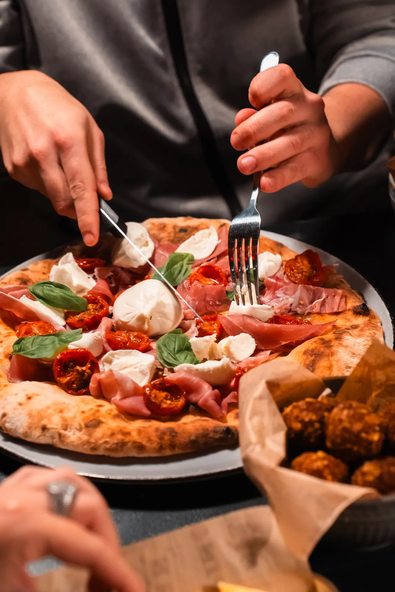 Mani che prendono una fetta di pizza