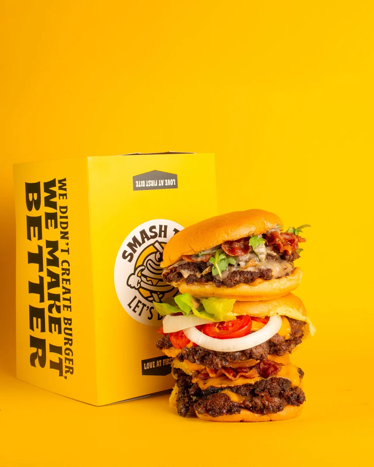 Box Smash Tag “We didn’t create burger, we make it better” con una torre di smash burger